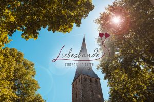 Schriftzug "Liebesbande - Einfach heiraten" vor einem Foto der St. Georgskirche Hattingen