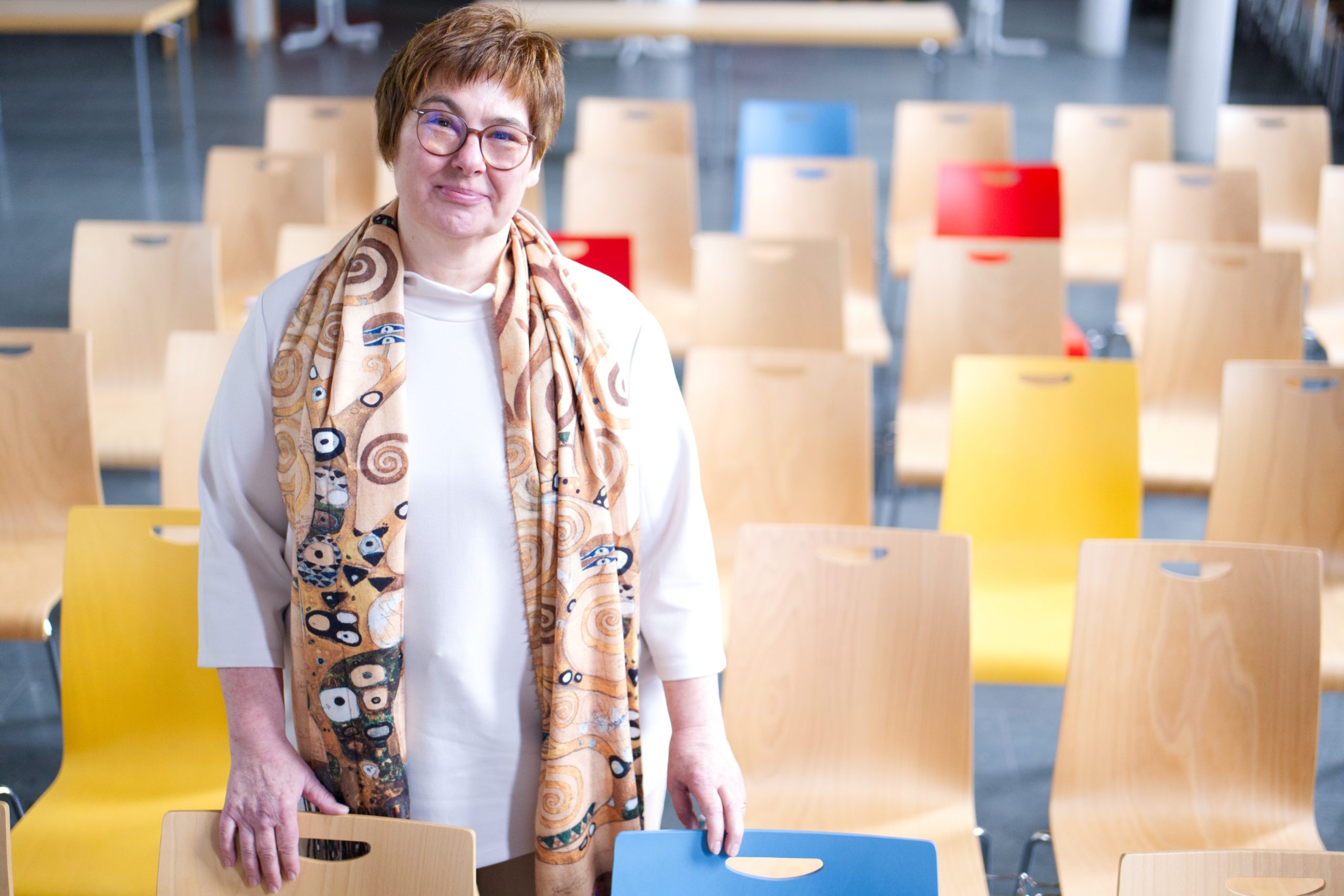 Sabine Maiwald-Humbert steht in der Friedenskirche inmitten der bunten Stuhlreihen (Foto: Hans-Martin Julius)