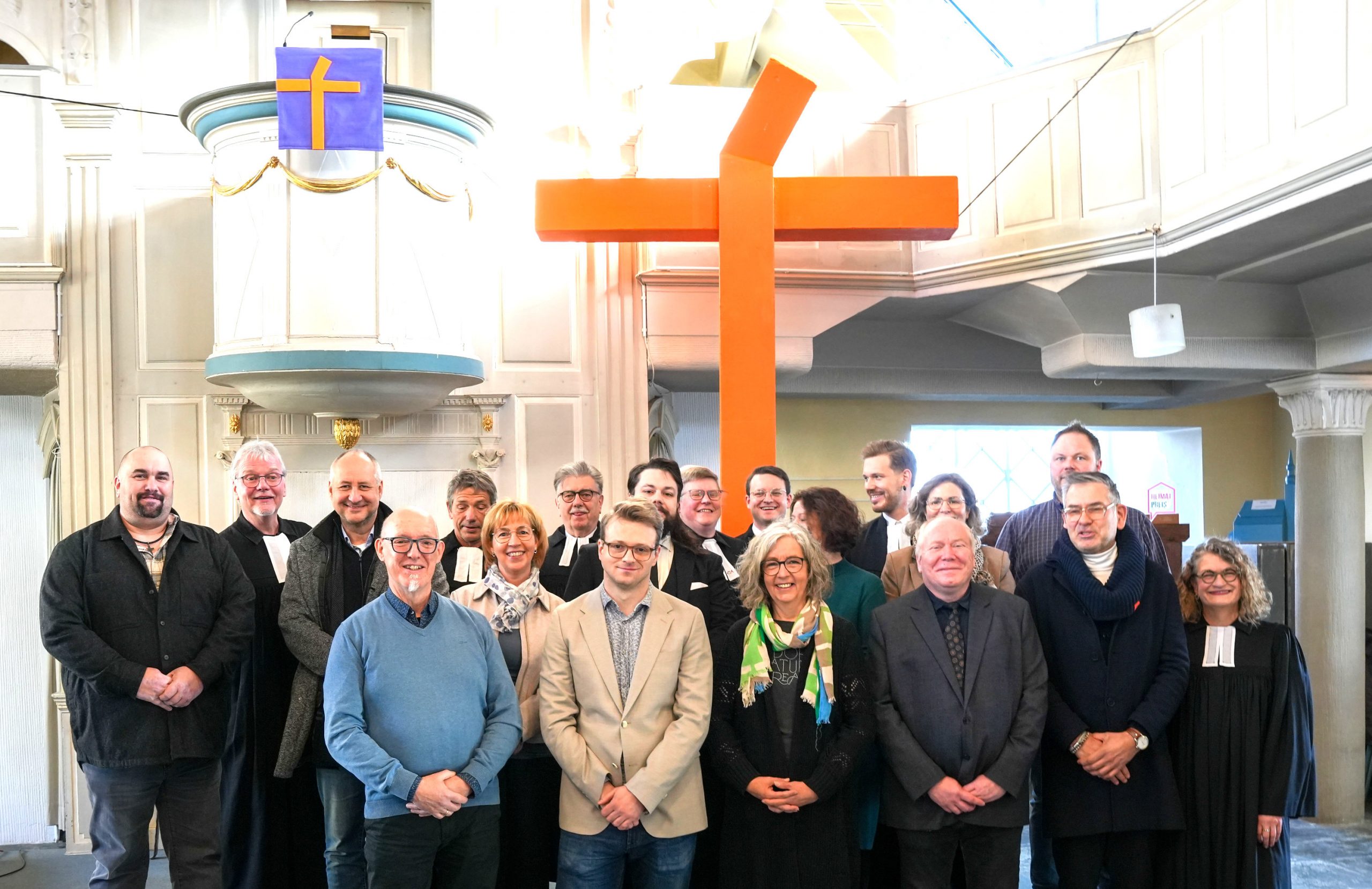 Der Bevollmächtigtenausschuss im Altarraum der Zwiebelturmkirche, im Hintergrund das Kreuz (c) Paul Funda