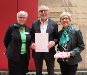 Ein Grüner Herr und zwei Grüne Damen mit Urkunde zum Jubiläum (Foto: EVA Ruhr)